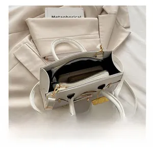 Internal view of white crocodile pattern handbag showing space for smartphone and wallet