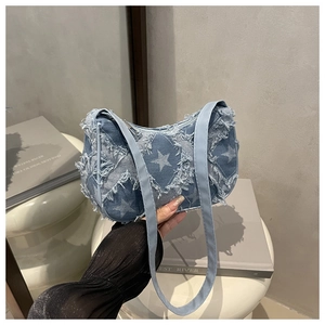 Détail du sac hobo en jean bleu avec motifs d'étoiles blanches et bords effilochés