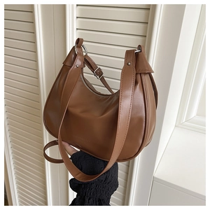 Detail of medium brown PU leather croissant bag featuring silver adjustable buckle and strap