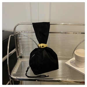 Elegant black suede bucket bag with round gold metal handle and chic drawstring detail