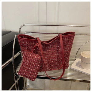 Détail du cabas en tweed rouge avec fil doré et petite pochette assortie sur étagère