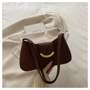 Detailed close-up of dark brown suede shoulder bag featuring a gold half-moon metal lock