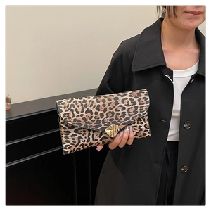 Close-up of leopard print envelope clutch featuring an irregular golden metal lock