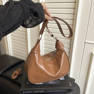 Brown faux leather crescent dumpling bag with silver rings and adjustable crossbody strap
