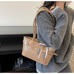 Détail du sac cabas en cuir verni kaki brillant avec ruban noeud et boucle métallique