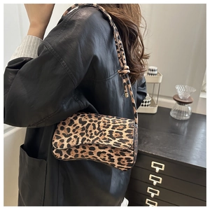 Detail of vintage leopard print shoulder bag with adjustable strap on a model