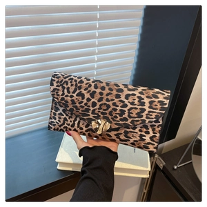 Detail of leopard print envelope clutch with a gold wavy metal buckle and PU leather texture