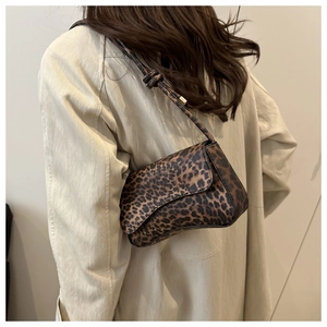 Detail of leopard print shoulder bag with knot strap detail on beige trench coat