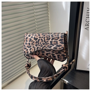 Detail shot of leopard print mini square bag featuring knotted strap and flap closure