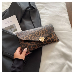 Detail of leopard print envelope clutch featuring a unique irregular gold metal buckle