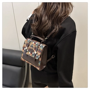 Macro detail of geometric patterned fabric and premium brown leather on a vintage backpack