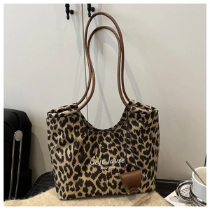 Detail view of the vintage leopard print tote bag with brown leather handles and text
