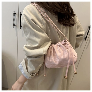Dettaglio della borsa a secchiello rosa con coulisse e tracolla a catena in pelle