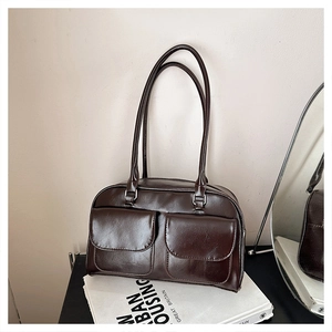 Détail du sac bandoulière vintage marron foncé avec deux poches à rabat brillantes