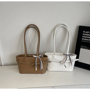 Détail de sacs portés épaule minimalistes avec rubans à carreaux sur marbre