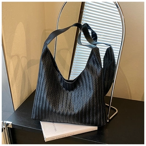 Detailed close-up of the black woven texture on a large capacity hobo shoulder bag