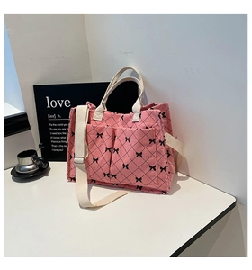 Detail of pink corduroy tote bag with black bow print and quilted texture design
