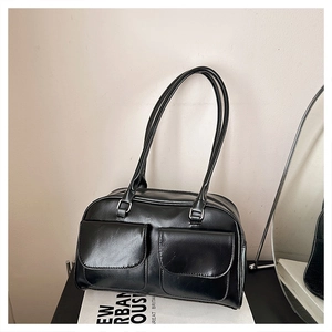Vue détaillée du sac bandoulière en cuir noir vintage avec deux poches avant aimantées