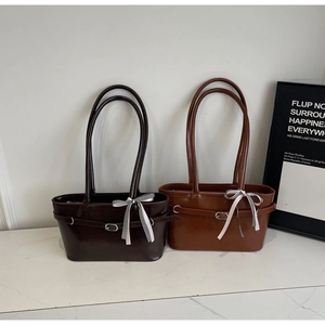 Détails de sacs d'épaule en cuir marron et caramel avec des nœuds à carreaux