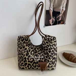 Retro leopard print tote bag with brown leather handles and decorative charm detail