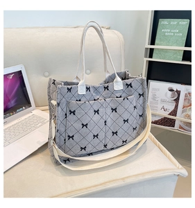 Detail of grey corduroy tote bag with black bows and spacious dual front pockets