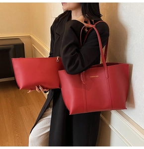 Detail view of red leather tote bag with gold stamped text and matching zipper pouch