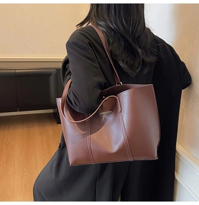 Detail of a dark brown leather tote bag with Fashion & Bags text on a shoulder strap