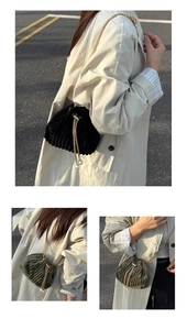 Detail of velvet corduroy bucket bag with gold chain strap and pearl drawstring accents