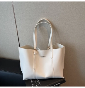 Detail of white leather tote bag featuring a Fashion & Bags print and adjustable shoulder strap