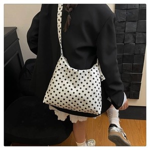 Detail of floral polka dot nylon tote bag showing its moon shape and strap texture