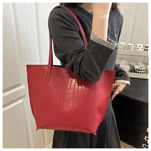 Detailed view of the red faux crocodile texture on the large commute tote bag