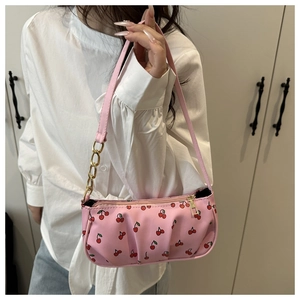 Detailed view of pink cherry print shoulder bag with gold chain and ruched design