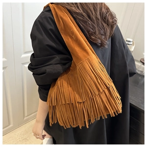 Dettaglio della borsa a tracolla boho in finta pelle scamosciata con frange