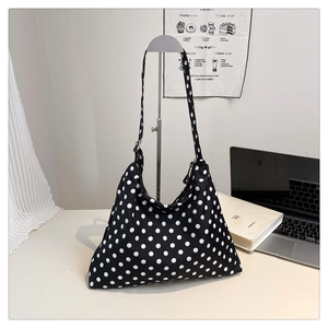 Close-up of black and white polka dot hobo tote bag with adjustable shoulder strap