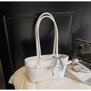 Close-up of minimalist white leather tote bag with silver buckle and checkered ribbon detail