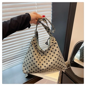 Detailed close-up of nylon tote bag with black polka dot pattern and zipper closure