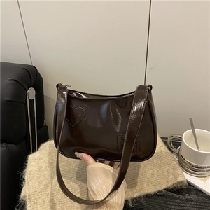 Dark brown patent leather underarm bag with heart patch and embossed M letter