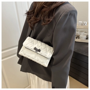 Crossbody view of white quilted flap square bag with gunmetal chain strap on model