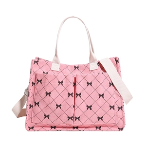 Pink corduroy tote bag with black bow lattice print and adjustable crossbody strap