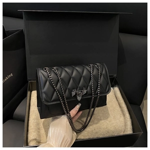 Dettaglio borsa trapuntata nera con chiusura opaca in confezione regalo di lusso