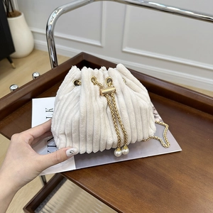 Minimalist beige corduroy bucket bag with gold chain and pearl drawstring details