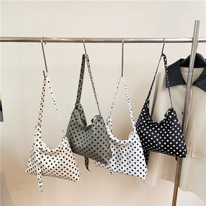 Chic polka dot nylon hobo tote bag in four colors displayed on a metal rack