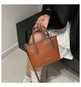 Detailed macro view of caramel lychee texture leather handbag with gold Fashion lettering