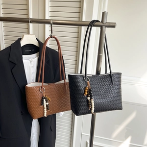 Chic woven leather tote bags in black and brown with delicate shoulder straps and bead tassels