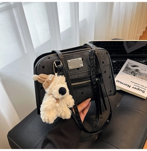 Détail du sac cabas en denim à pois noirs avec ours en peluche et plaque logo argentée