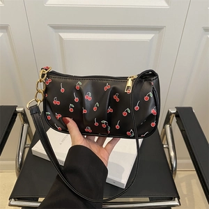 Chic black underarm bag with red cherry print, golden chain and zipper detail