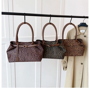 Detailed view of three leopard print suede tote bags in brown, green, and tan shades