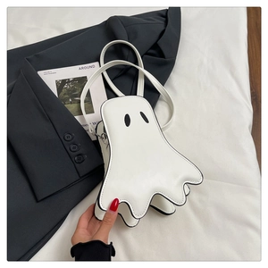 Detail shot of a white ghost-shaped crossbody bag with black piping and matching strap