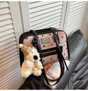 Detail of pink polka dot tote bag with metal nameplate and cute white bear charm