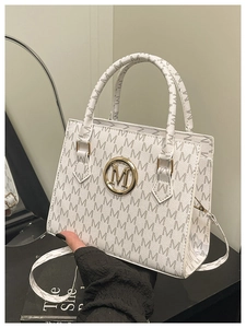 Dettaglio borsa bianca con motivo monogramma e logo M dorato con tracolla rimovibile